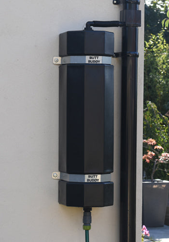 A black ButtBuddy rainwater management system mounted on a wall