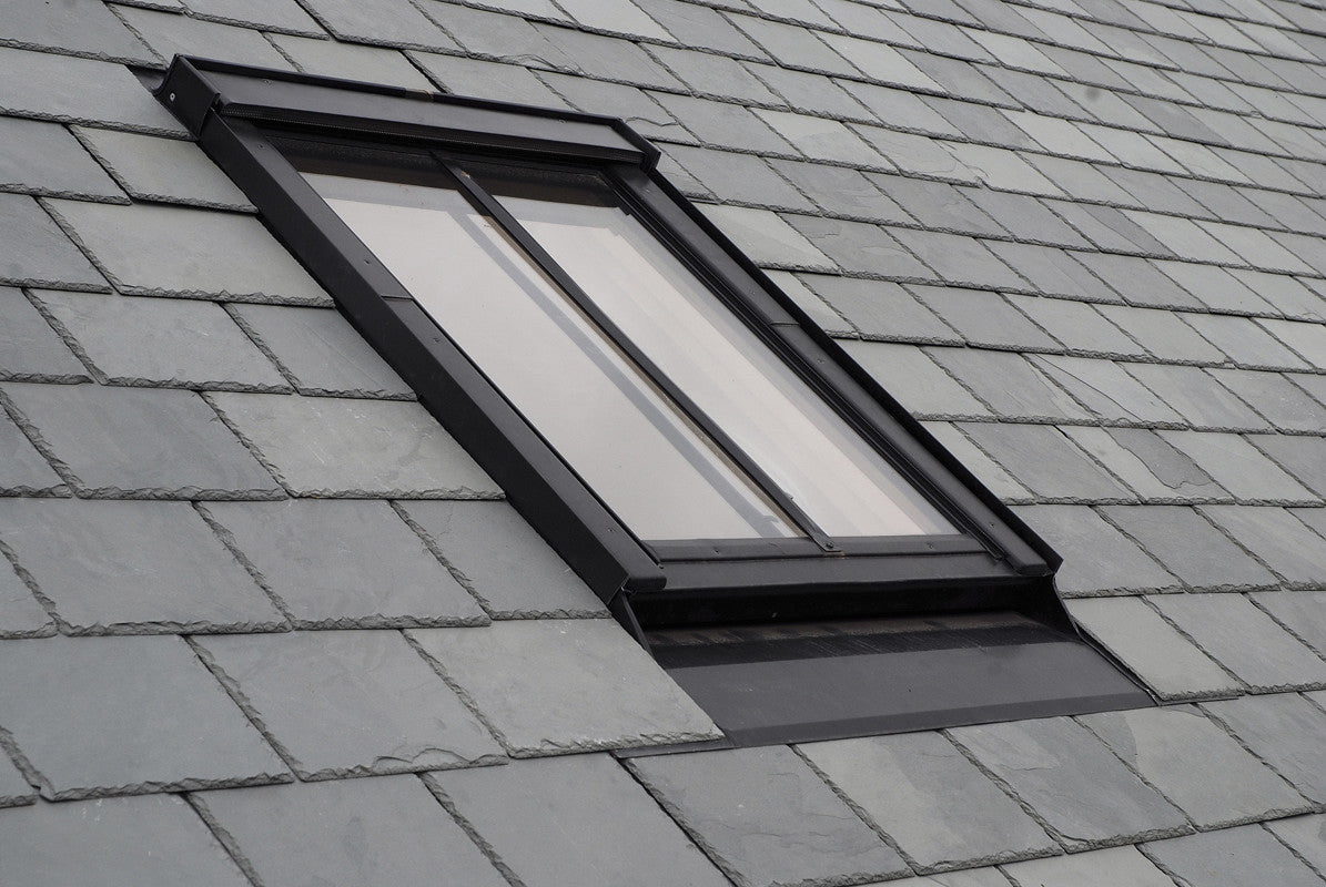 A FAKRO skylight installed on a roof with interlocking tiles.