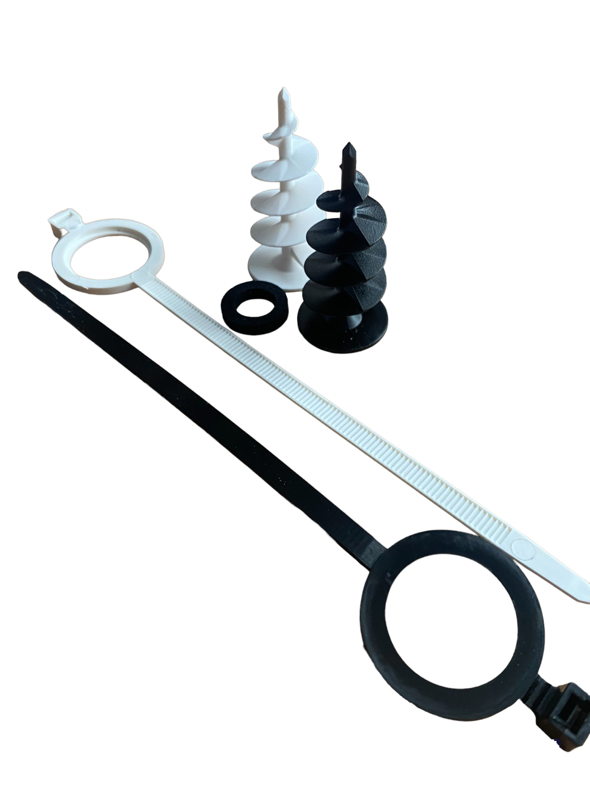 Surface Mounted Pipe and Cable Connection Kit, including a black spiral fitting, a black cable tie, a neoprene washer, and a metal rod.