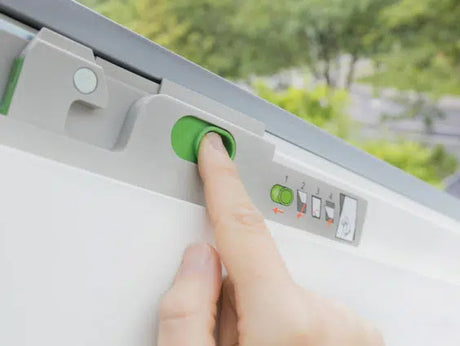 Hand pressing a green button on window